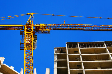 ConConstruction crane near the building under construction. Construction site. Industrial background.