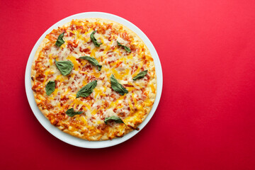 Classic cheese pizza over colourful red background with copy space. Fast food.