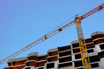 Сrane near building. Concrete building under construction.