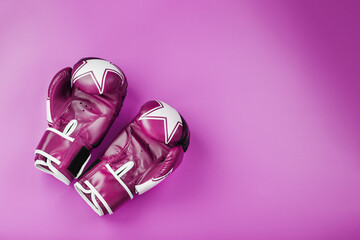 Pink Boxing gloves on a pink background, free space.