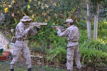 Dos jovenes apuntandose con fusiles de airsoft