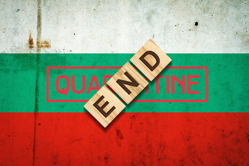 End of quarantine. The inscription on wooden blocks on the background of the flag of Bulgaria. The end of the pandemic. Business.