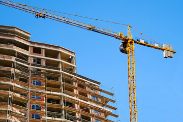 Construcrion site background. Red ick building under construction. Big tower crane. Industrial background.