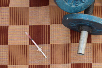Syringe and stethoscope on a surface. Doping in gym