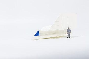 Miniature people : Close up engineer with paper airplane isolated on white background 