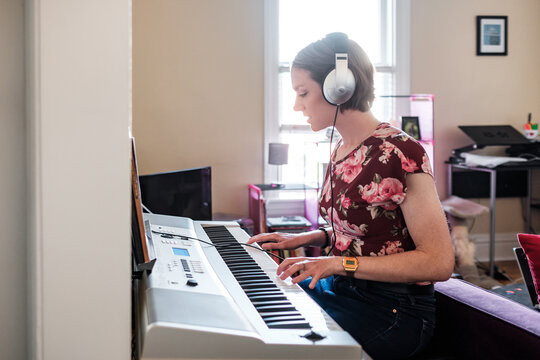 Woman playing piano keyboard at home