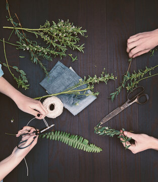 Overhead hands making natural decorations