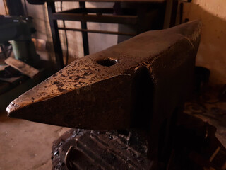 Hammer and old rusty anvil in blacksmith workplace