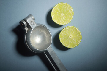 exprimidor de jugo de limón con limón a la mitad sobre fondo plano