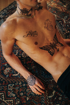 Anonymous Handsome Man With Tattoos Lying On The Floor