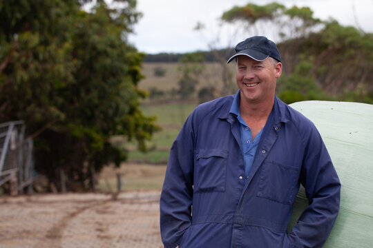 Dairy farmer leaning on hay bale