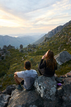 Hiking couple smoking a joint at sunset