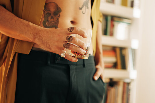 Close Up Of Anonymous Tattoed Man Having A Drink At Home