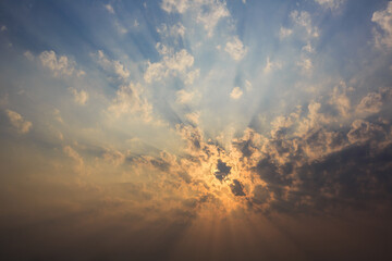 The sky is covered with clouds and the sun's rays penetrate