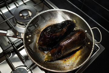 Eggplants cooking on open flame for Baingan Bharta dish