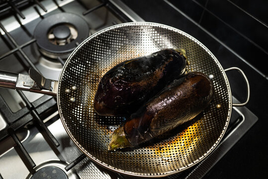 Eggplants cooking on open flame for Baingan Bharta dish