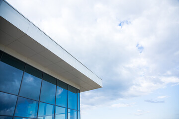 Fototapeta na wymiar Clouds reflected in windows of modern office building