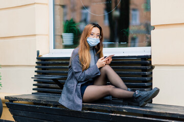 Young fsian woman wearing face mask is standing at a domestic street. New normal covid-19 epidemic