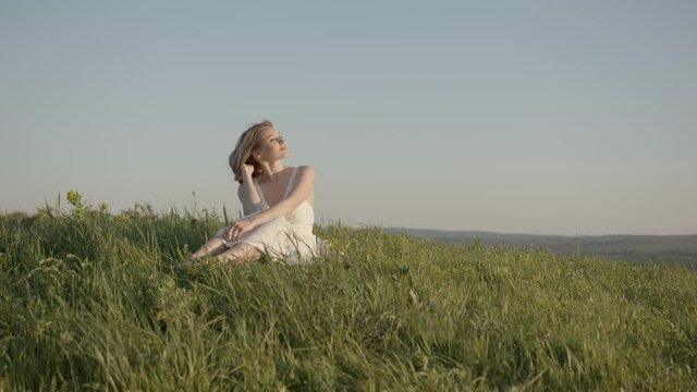 young girl in a white dress enjoys life on the meadow