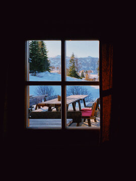 Fototapeta Snowy landscape out of mountain chalet window at sunset