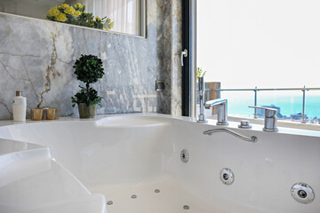 Hot tub near the window with sea view of luxurious hotel room. - obrazy, fototapety, plakaty
