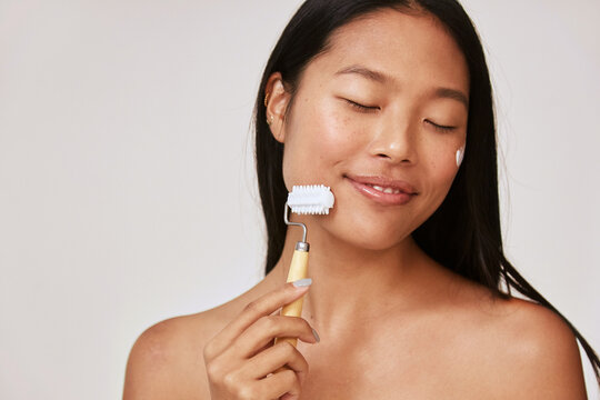 Woman enjoying face massage - Skincare facial roller