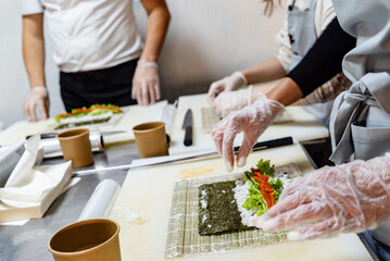 people making sushi on kitchen