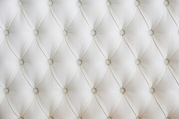 Close up shot of buttoned eco leather headboard of the bed. Copy space, background.