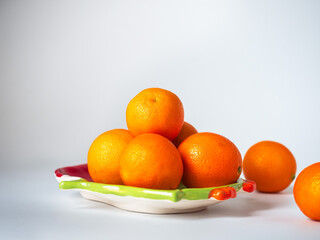 Tangerines on a New Year's plate on a white background