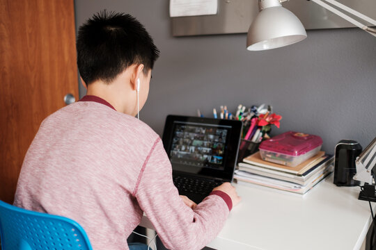 Asian Kid Having a Virtual Meeting With His Classmates at Home