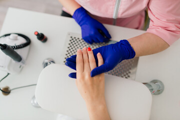 Female manicure master in a beauty salon work with hands of the client