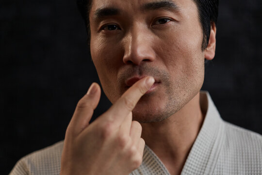 Adult man hydrating lips at home