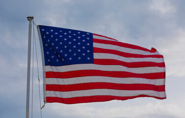 Stars and stripes flying with sky behind