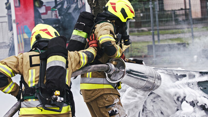 Fire drill. Firefighters extinguish fire from the nurning car using the foam. High quality photo
