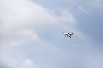 Quadcopter drone in sky. Small drone flies in sky taking video and photos. Remote control air delivery and spy. selective focus.