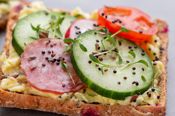 Sandwiches with cream cheese, vegetables and salami.
