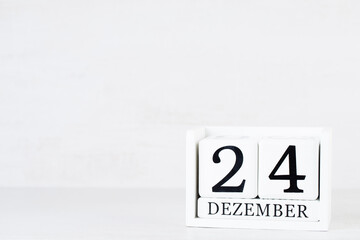 Wooden Calendar December 24 Christmas Day. On a gray background with christmas decor.