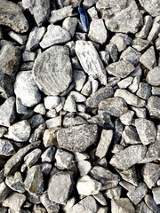texture of large rounded stones of different sizes in different shades of gray, the top view is close to the background