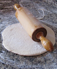 rolling pin with dough and flour