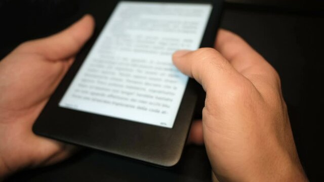 Young man using digital ebook reader at home,new book reading technology 