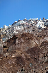 Mutnovsky volcano. A large snowfield on the mountainside on blue sky