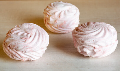 three light pink candy on the table.