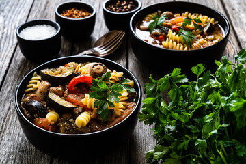 Pork ragout with fusilli and champignon on wooden table

