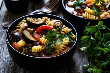 Pork ragout with fusilli and champignon on wooden table
