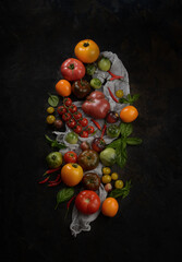 Fototapeta na wymiar Colored tomatoes on a dark background. Top view. Rustic style