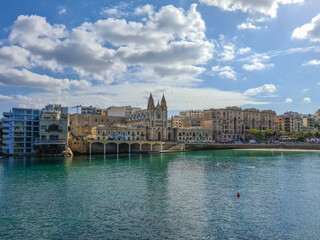 Fototapeta premium The Parish Church of Our Lady of Mount Carmel and the Balluta Buildings in Balluta Bay, Malta.