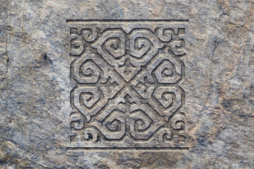 Ornamental print on the stone surface. Vintage ornament on the stone. Close-up seamless texture. Stone texture. Pattern on the stone. Embossed pattern. Wallpaper.