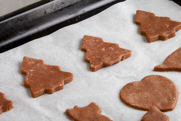 The dough in the shape of a Christmas tree lies in a pan, ready for baking
