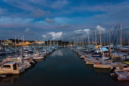 Sailboats Moored At Harbor Against Cloudy Sky