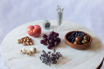 Natural ingredients on an antique marble table, a rustic bowl, and glass jars set with a branch of privet. Healthy and vegetarian food.